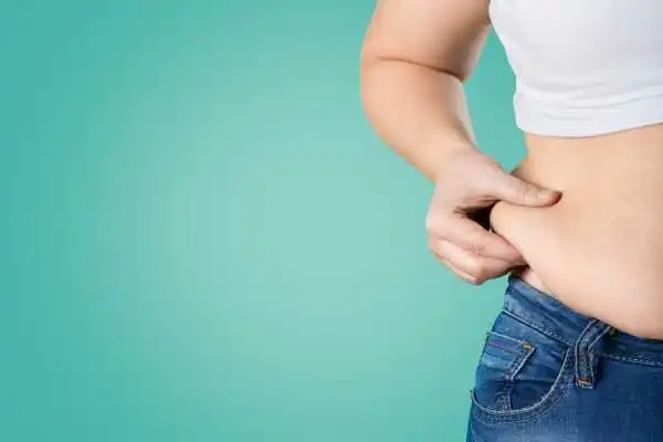 Image of woman pinching her love handles to show weight gain East Malling